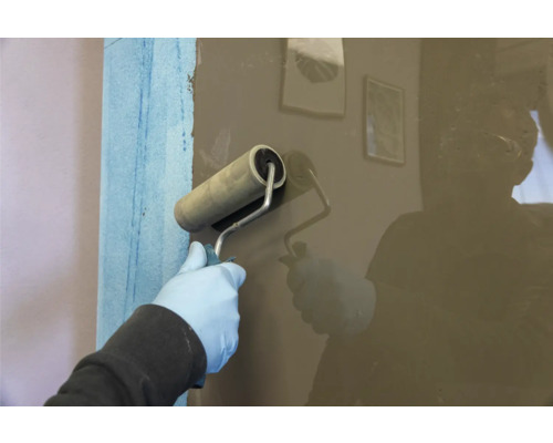 Application d'un revêtement à l'aide d'un rouleau à peinture sur un mur