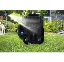 Nettoyage d'un robot de tonte avec un jet d'eau sur une pelouse