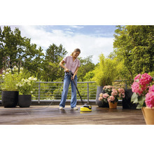 Femme nettoie terrasse avec un nettoyeur de terrasse.