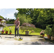 Un homme nettoie une terrasse avec un nettoyeur de terrasse