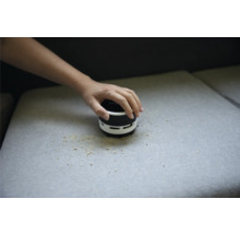 Tischstaubsauger wird zum Reinigen von Krümeln auf dem Sofa verwendet