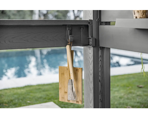Planche à découper en bambou et ustensiles de barbecue suspendus à un toit de terrasse