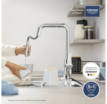 Robinet de cuisine avec douchette extractible et robinet dans l'évier, avec le logo Grohe au-dessus.