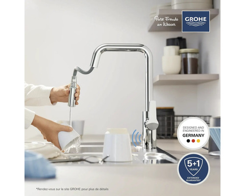 Robinet de cuisine avec douchette extractible et robinet dans l'évier, avec le logo Grohe au-dessus.