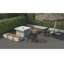 Gartenszene mit Sitzgruppe, Tisch und Sonnenschirm auf einer Terrasse.
