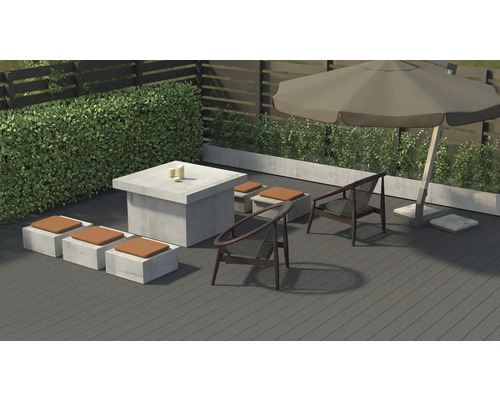Gartenszene mit Sitzgruppe, Tisch und Sonnenschirm auf einer Terrasse.