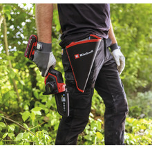 Eine Person mit einer Einhell Akku-Astsäge und einem Holster mit Einhell Logo