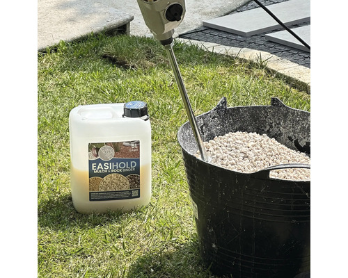 Seau avec des pierres, agitateur et liant pour paillis et pierres EasiHold sur l'herbe