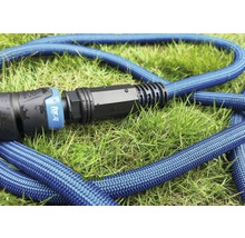 Blauer Gartenschlauch mit Anschlussstück auf Gras