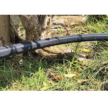 Bewässerungsschlauch im Garten mit austretendem Wasser