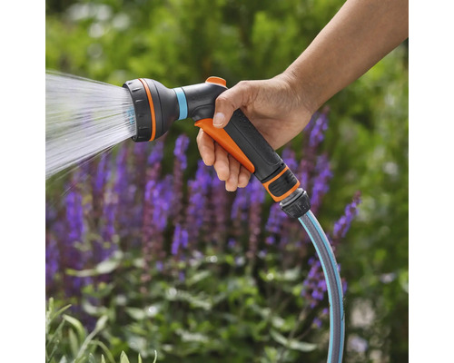 Main tenant un pistolet d'arrosage de tuyau d'arrosage avec jet d'eau