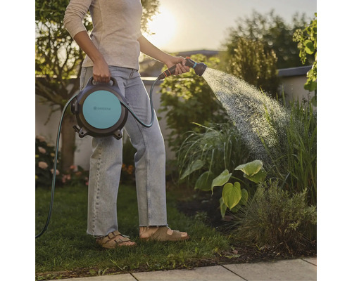 Frau bewässert Garten mit Gardena Schlauchbox