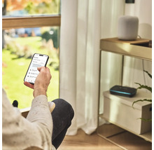 Une personne utilise une application d'arrosage de jardin sur un smartphone