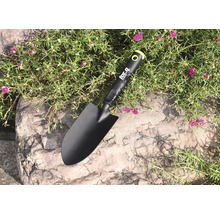 Gartenschaufel auf Steinuntergrund zwischen Pflanzen