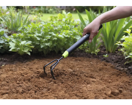 Gartenkralle im Einsatz zum Auflockern von Erde im Gartenbeet