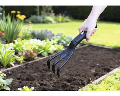 Griffe de jardin en utilisation dans une plate-bande de légumes.
