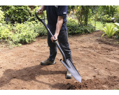 Homme tenant une bêche dans le jardin.