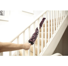 Une personne nettoie une rampe d'escalier avec un plumeau.