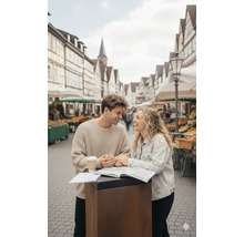 Ein Paar steht an einem Stehtisch auf einem Marktplatz und betrachtet eine Karte.