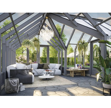 Jardin d'hiver avec coin salon, table et plantes décoratives.