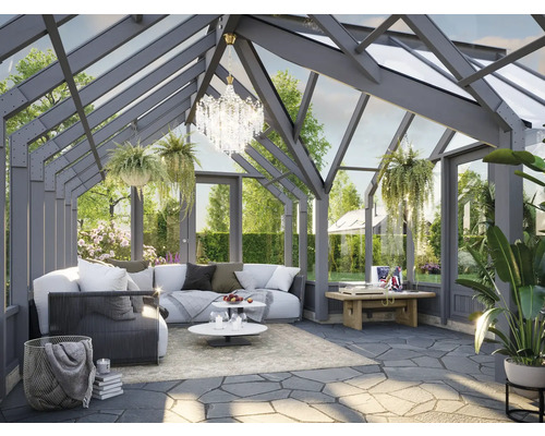 Jardin d'hiver avec coin salon, table et plantes décoratives.