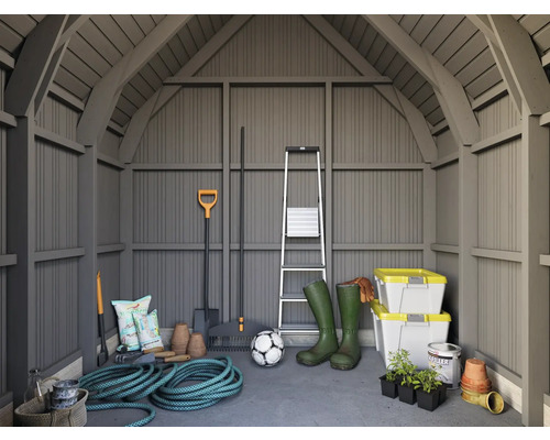 Intérieur d'abri de jardin avec outils de jardinage, échelle, bottes en caoutchouc et boîtes de rangement