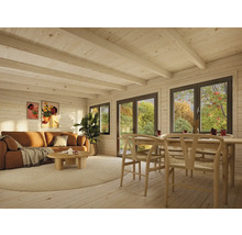 Intérieur de maison en bois avec canapé, table et chaises devant des fenêtres.