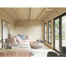 Intérieur d'une cabane de jardin avec revêtement en bois, canapé et fenêtres.