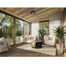 Véranda lumineuse avec coin salon, plantes et portes coulissantes