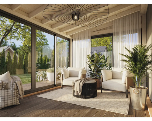 Véranda lumineuse avec coin salon, composé de canapés, fauteuil et plantes