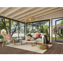 Salon avec fauteuil en rotin, canapé, table basse et vue sur le jardin