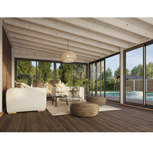 Véranda lumineuse avec coin salon, table et vue sur le jardin avec piscine