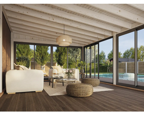 Véranda lumineuse avec coin salon, table et vue sur le jardin avec piscine