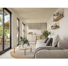 Espace de vie lumineux avec canapé, étagères, comptoir de cuisine et porte-fenêtre