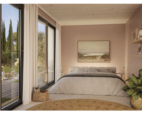 Chambre lumineuse avec lit double, tableau et grandes fenêtres donnant sur le jardin