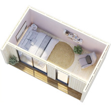 Vue de dessus d'une petite chambre avec lit, fauteuil et tapis rond.