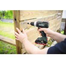 Une personne visse une palette en bois avec une visseuse sans fil de la marque Metabo.