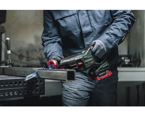 Une personne coupe un tube métallique avec une scie sabre Metabo.