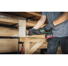 Une personne utilise une scie sabre sans fil Metabo pour couper un morceau de bois.
