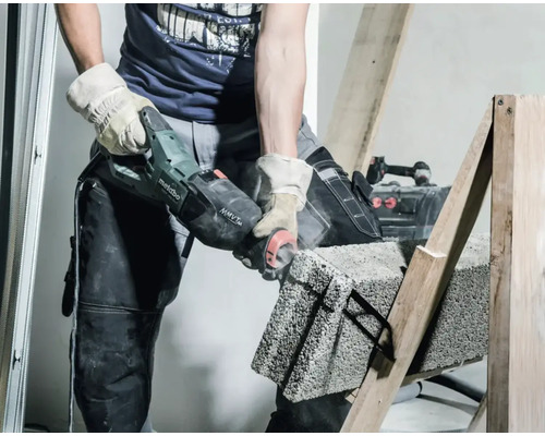 Un homme coupe une pierre avec une scie à pierre sur un châssis en bois