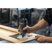 Défonceuse manuelle en utilisation sur un cadre en bois