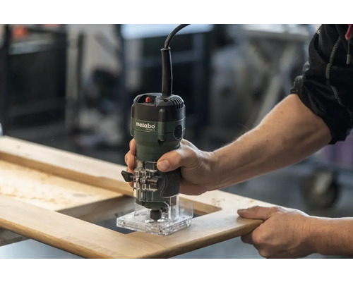 Défonceuse manuelle en utilisation sur un cadre en bois