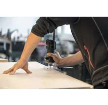 Personne travaillant avec une défonceuse sur une pièce