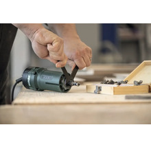 Une personne change la fraise d'une défonceuse Metabo