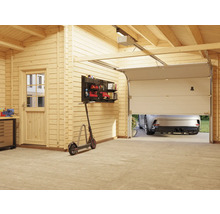 Innenansicht einer Garage mit Holzverkleidung, Garagentor, Werkzeugwand und einem Auto im Hintergrund