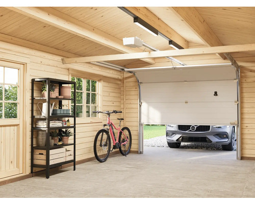 Garage lumineuse avec étagères, vélo et porte de garage partiellement ouverte avec une voiture derrière