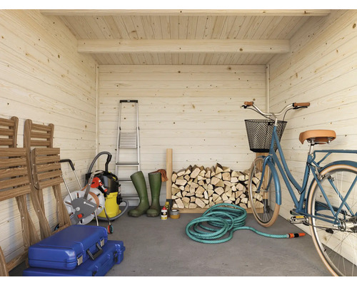 Vue intérieure d'une cabane de jardin en bois clair avec échelle, bûches, vélo et outils de jardinage