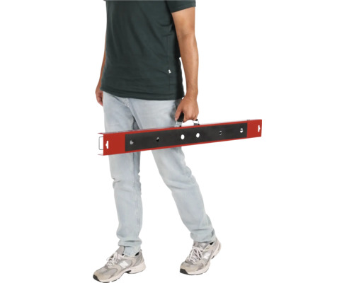 Un homme porte une barre de nivellement