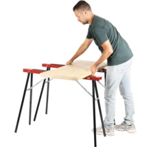 Un homme pose une planche en bois sur deux tréteaux