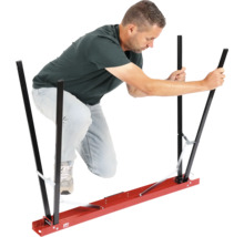 Un homme utilise un dispositif de transport pour plaques de plâtre.